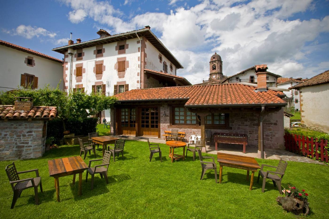 Jardín de una casa rural con sillas y mesas